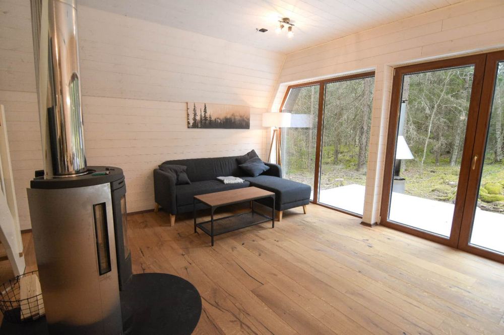 Wohnzimmer-mit-Kamin-mit-Blick-in-die-Natur-Schwedenofen-Holz